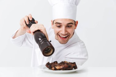 Neşeli şef yemek giyen üniforma biber sığır eti biftek beyaz arka plan üzerinde izole bir plaka üzerinde pişmiş