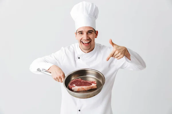 Cheerful Cozinheiro Chef Vestindo Uniforme Mostrando Frigideira Com Bife Cru — Fotografia de Stock