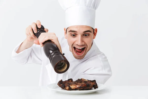 Χαρούμενα Σεφ Μάγειρας Φορώντας Στολή Πιπεριές Που Μαγειρεύονται Μοσχαρίσια Μπριζόλα — Φωτογραφία Αρχείου