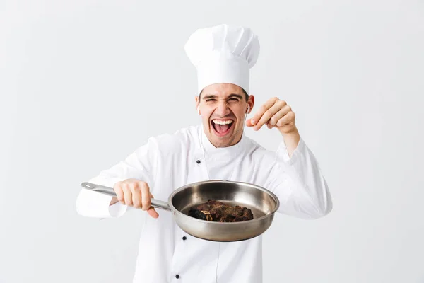 Χαρούμενα Σεφ Μάγειρας Φορώντας Στολή Δείχνει Τηγάνι Μαγειρεμένα Μοσχαρίσια Μπριζόλα — Φωτογραφία Αρχείου