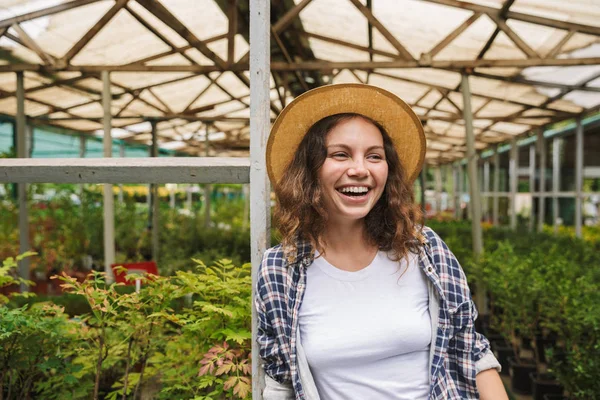 若い花屋女性 代の肖像画ポーズと温室での植物の上の作業 — ストック写真