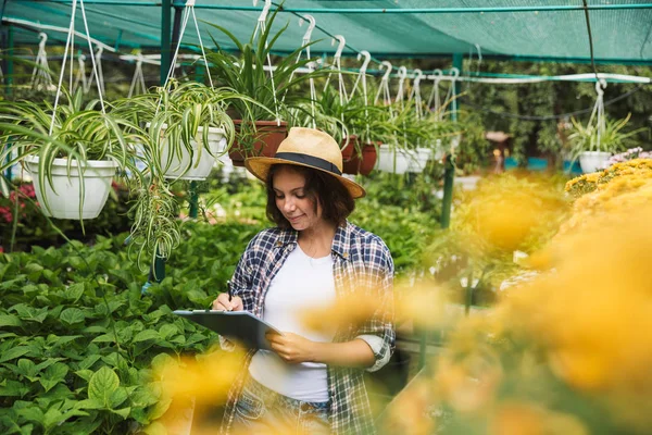 Pretty Young Woman Working Greenhouse Writing Notes Tablet — Stock Photo, Image