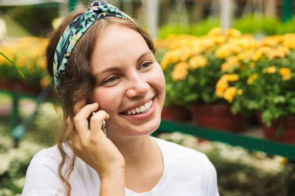 Jovem Jardineira Alegre Falando Telefone Celular Enquanto Está Dentro Uma — Fotografia de Stock