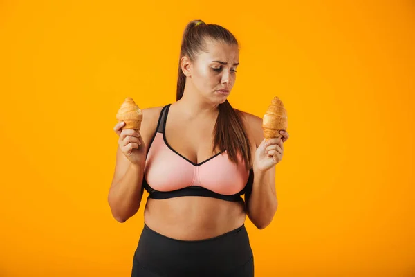 Image Serious Chubby Woman Tracksuit Holding Two Croissants Both Hands — Stock Photo, Image