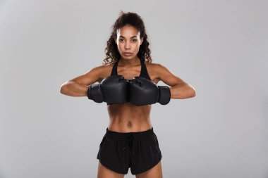 Gri arka plan üzerinde izole boks yapıyor bir afro Amerikan kendine güvenen genç sporcumuz portresi