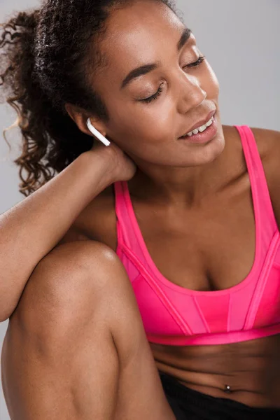 Attractive Young African Sportswoman Earphones Sitting Isolated Gray Background — Stock Photo, Image