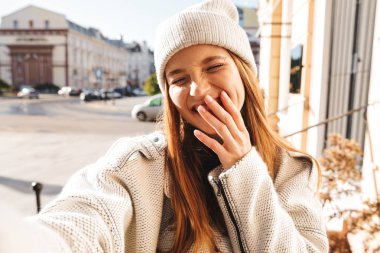 Güzel ve genç birbayan sonbahar ceket ve açık havada yürüyüş, bir selfie alarak bir şapka giymiş