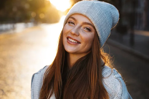 秋のコートと野外を歩いている街で帽子を着て陽気な若い女性 — ストック写真