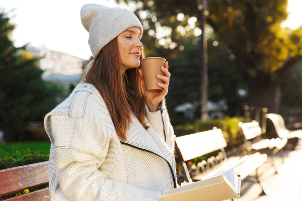 Beeld Van Een Roodharige Vrouw Zittend Bankje Buiten Bedrijf Leesboek — Stockfoto