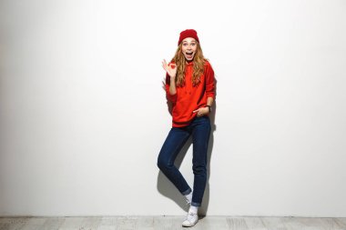 Tam uzunlukta hoodie ayakta beyaz arka plan üzerinde giyen mutlu bir genç kadın portresi