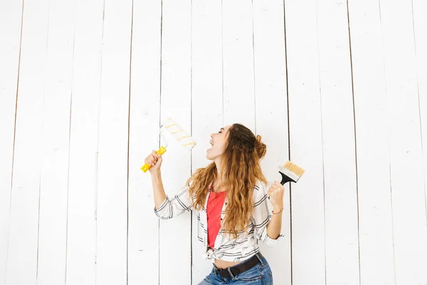 Imagen Mujer Alegre 20S Sosteniendo Rodillo Pincel Mientras Pinta Pared — Foto de Stock