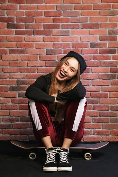 Afbeelding Van Vrij Sportief Meisje 20S Lachen Zittend Het Skateboard — Stockfoto