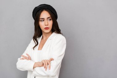 Uzak seyir gri arka plan üzerinde izole bere ayakta giyen bir genç kadın portresi