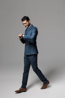 Tam boy görüntü resmi elbise gri arka plan üzerinde izole yürüme neşeli Arap adamın 30'lu