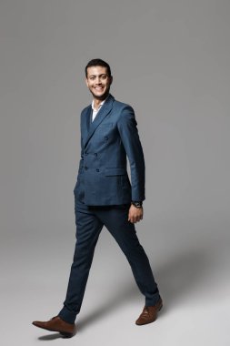 Tam boy görüntü resmi elbise gri arka plan üzerinde izole yürüme tıraşsız Arap adamın 30'lu