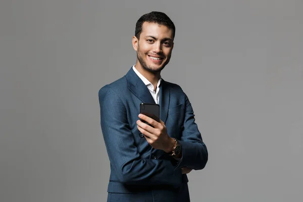 Bilden Stilig Affärsman Som Håller Mobiltelefon Poserar Isolerade Över Grå — Stockfoto