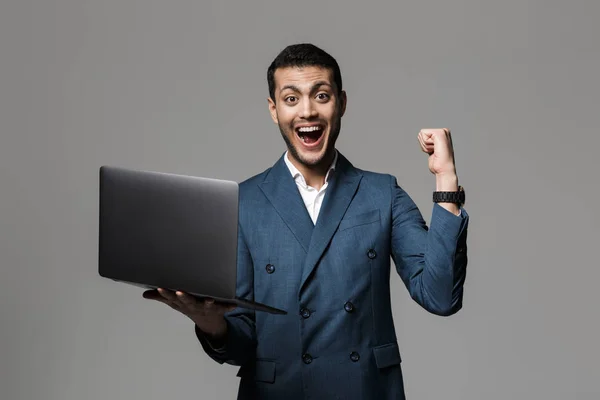 Зображення Збудженого Арабського Чоловіка 30Х Діловому Костюмі Посміхається Тримає Ноутбук — стокове фото