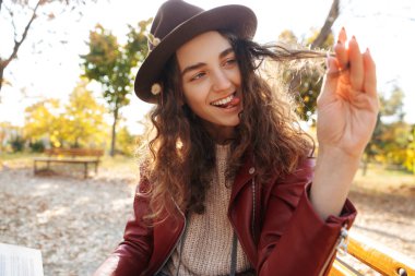 Kitap okuma parkta bir bankta oturan neşeli genç kız