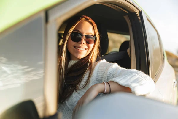 Sonriente Jovencita Conduciendo Coche Atardecer Mirando Ventana —  Fotos de Stock