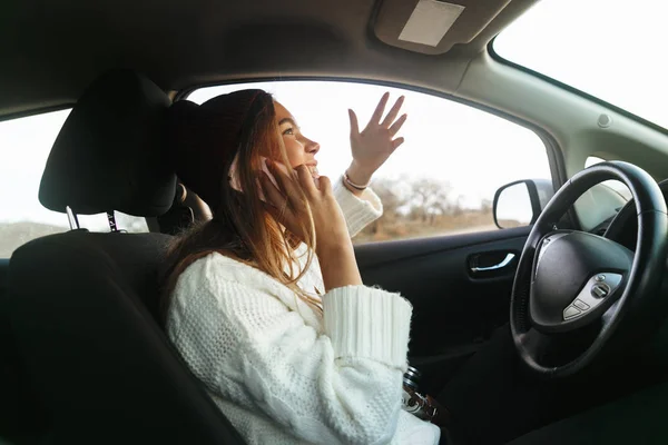 車の中に座って携帯電話で話している若い美人 — ストック写真