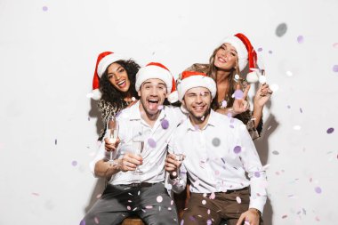 Group of cheerful smartly dressed friends celebrating New Year isolated over white background, drinking sparkling champagne clipart