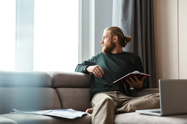 Knappe Jongeman Thuiswerken Zittend Een Bank Met Behulp Van Laptopcomputer — Stockfoto