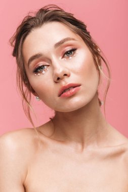 Güzellik Portresi beyaz inci giymiş pembe arka plan üzerinde izole çekici bir genç üstsüz kadın poz