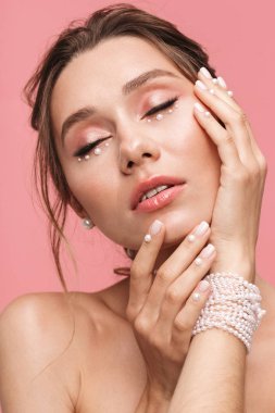 Güzel bir genç kadının poz görüntü pembe duvar arka plan üzerinde izole.