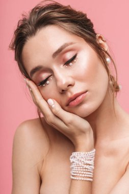 Güzel bir genç kadının poz görüntü pembe duvar arka plan üzerinde izole.