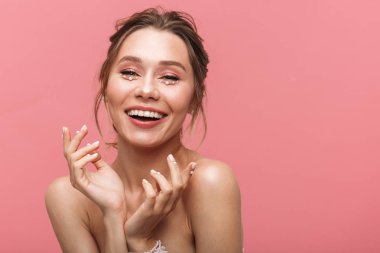 Güzellik Portresi beyaz inci giymiş pembe arka plan üzerinde izole çekici bir genç üstsüz kadın poz