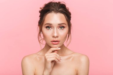 Güzellik Portresi beyaz inci giymiş pembe arka plan üzerinde izole çekici bir genç üstsüz kadın poz