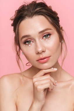 Güzel bir genç kadının poz görüntü pembe duvar arka plan üzerinde izole.