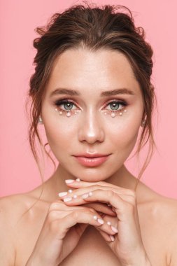 Güzellik Portresi beyaz inci giymiş pembe arka plan üzerinde izole çekici bir genç üstsüz kadın poz