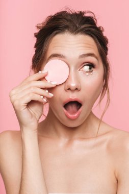 Pamuk disk tutarak pembe duvar arka plan üzerinde izole poz bir güzel şok mutlu genç kadın fotoğrafı.