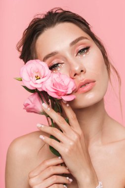 Çiçekli pembe duvar arka plan üzerinde izole görüntü oldukça genç bir kadının poz.