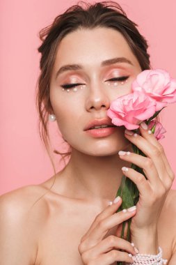 Çiçekli pembe duvar arka plan üzerinde izole görüntü oldukça genç bir kadının poz.