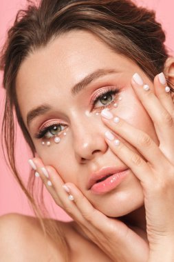 Güzellik kapatın beyaz inci giymiş pembe arka plan üzerinde izole poz çekici bir genç üstsüz kadın portresi