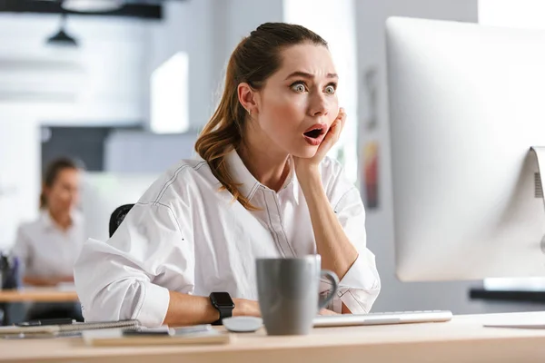 Шокированная Молодая Женщина Одетая Рубашку Сидит Работе Смотрит Компьютер — стоковое фото