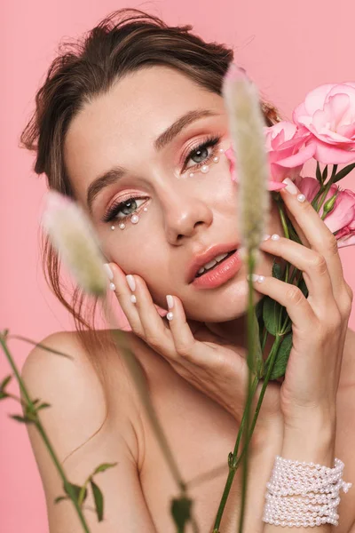 Obrázek Hezké Mladé Ženy Představují Samostatný Růžové Zdi Pozadí Květinami — Stock fotografie