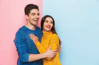Neşeli genç çift iki renkli arka plan üzerinde izole ayakta sarılma