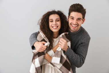 Çift erkek ve kadın gülümseyerek ve birlikte sarılma battaniyeye sarılmış fotoğraf gri arka plan üzerinde izole