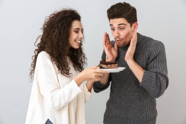 Kolay mum tutan Doğum günü kutluyor gri arka plan üzerinde izole ayakta kazak giyen çift