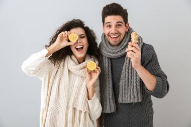 Mutlu çift erkek ve limon ve gri arka plan üzerinde izole zencefil tutan tulum giyen kadın fotoğrafı