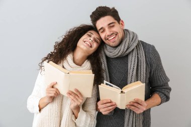 Görüntü memnun çift erkek ve kadın birlikte gri arka plan üzerinde izole kitap okuma