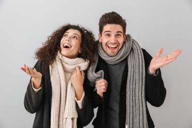 Kazak ve ayakta ararken gri arka plan üzerinde izole tulum giyen genç çift