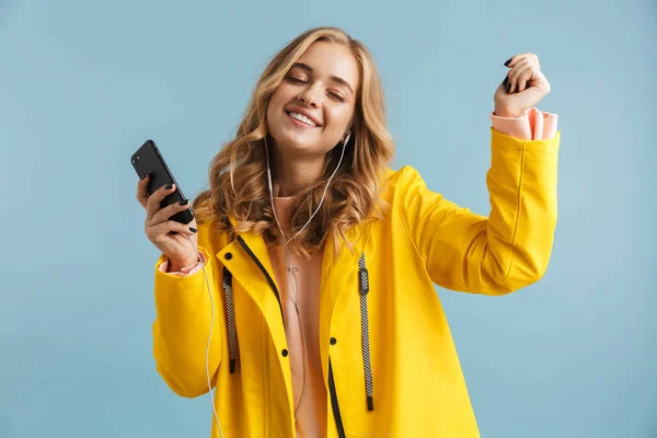 Obraz Piękna Kobieta 20S Noszenia Żółty Płaszcz Posiadania Telefonu Komórkowego — Zdjęcie stockowe