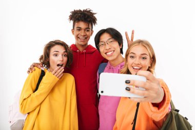 Neşeli Genç beyaz arka plan üzerinde izole sırt çantaları, bir selfie alarak taşıyan grup