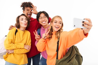 Neşeli Genç beyaz arka plan üzerinde izole sırt çantaları, bir selfie alarak taşıyan grup