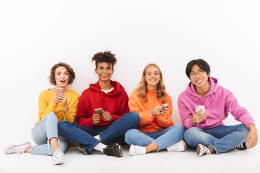 Cep telefonunu kullanarak beyaz bitti, izole grup neşeli çok ırklı arkadaşıyla oturan