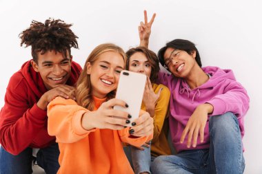 Neşeli Genç beyaz arka plan üzerinde izole bir selfie alarak Grup